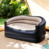 Gardeon inflatable outdoor air sofa with pump set up on a grassy campsite.