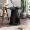 Palmer Charcoal Chic black wood side table placed next to a modern grey sofa